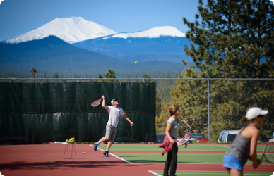 Tennis players playing on tennis courts overlooking the sweeping cascade views