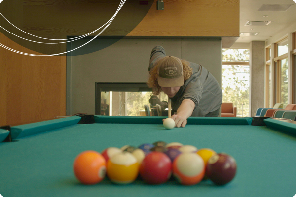 Student playing billiards, one of the amenities offered at Wickiup Hall