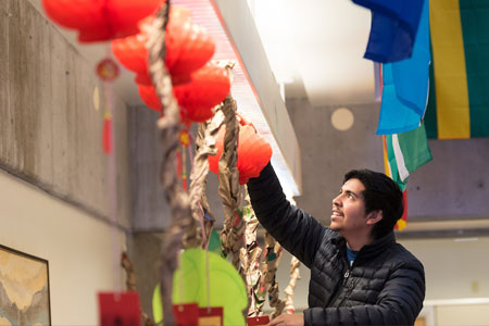 Community college student hanging paper lantern in ethnic studies