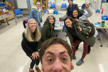 Education Program student and faculty taking a fun group selfie in a classroom