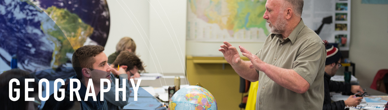 Geography professor teaching students with a world globe