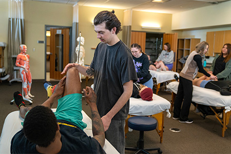 Students practicing massage in a classroom.
