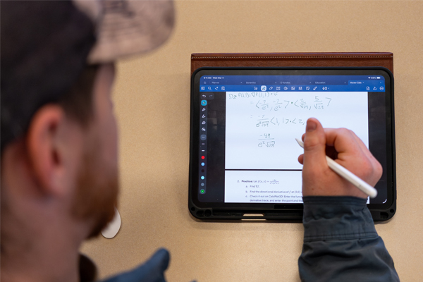 Close-up of a student using an Apple Pencil to work through math equations on an iPad.